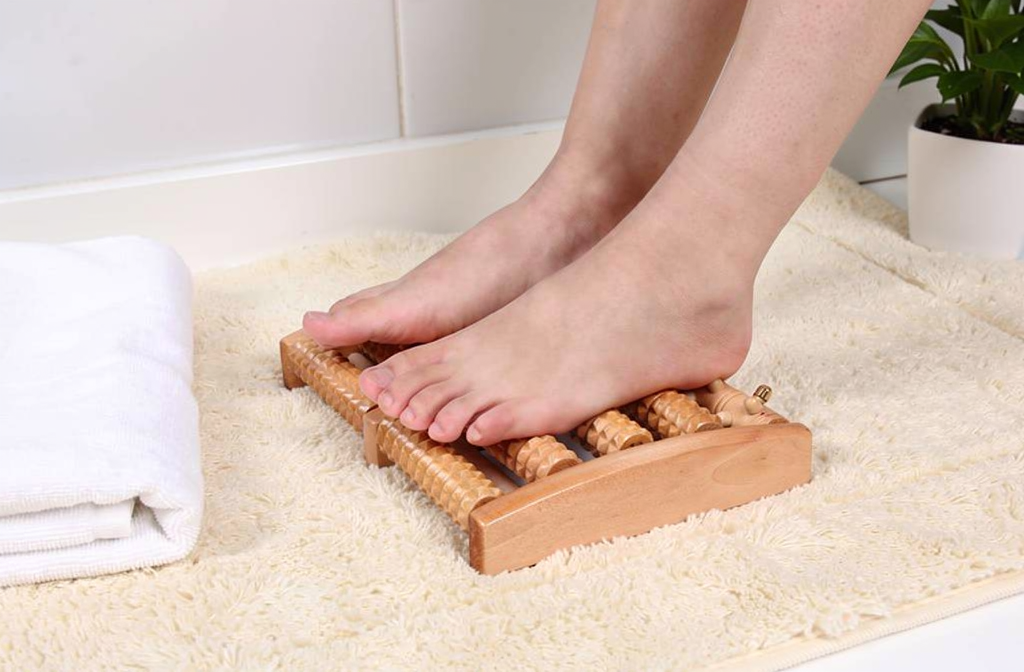 Rouleau de massage des pieds en bois utilisé dans une salle de bain apaisante